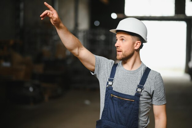 Portrait of happy male worker in warehouse standing between shelves