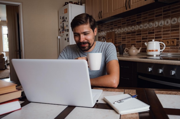 キッチンで一杯のコーヒーを持っている幸せな男の肖像