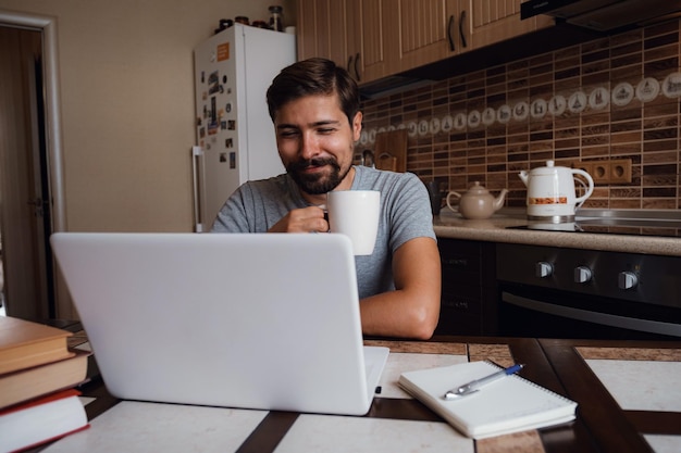 キッチンで一杯のコーヒーを持っている幸せな男の肖像