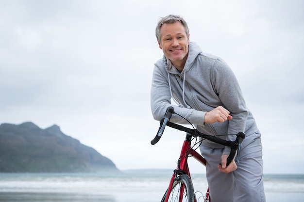 ビーチで自転車にもたれて幸せな男の肖像