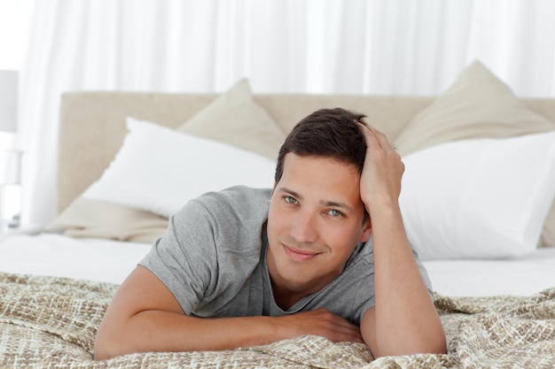 Portrait of a happy man relaxing on his bed