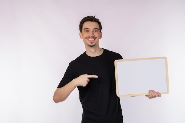 Portrait of happy man showing blank signboard on isolated white background