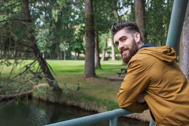 Portrait of a happy man, smiling, enjoying nature in the autumn time, near the river