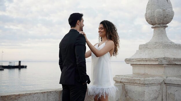 Portrait of happy man in suit and woman in white short dress and curly flying hair action lovely