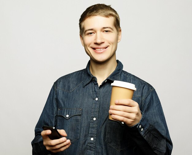 Ritratto di uomo felice che parla al telefono e beve caffè