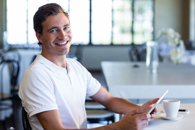 Portrait of happy man using digital tablet