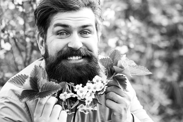 A portrait of happy man with white flowers on the head spring mans fashion photo