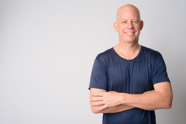 Portrait of happy mature handsome bald man smiling with arms crossed