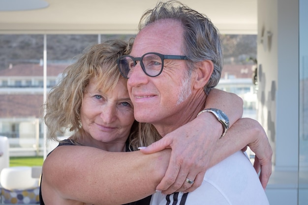 Portrait of happy mature middle aged family couple smiling embracing romantic man and blonde woman