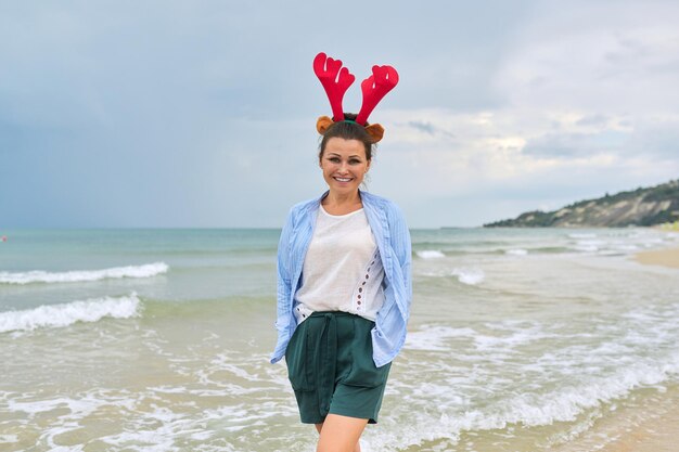 카메라를 보고 웃 고 해변에서 휴가 귀에 행복 한 성숙한 여자의 초상화. 크리스마스 새해, 열대 리조트에서의 축하, 여행 관광 사람들 개념