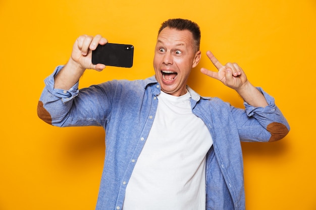 Portrait of a happy middle aged man taking a selfie