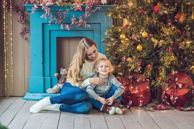 Portrait of happy mother and adorable boy celebrate Christmas. New Year's holidays