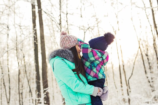 Portrait of happy mother and baby in winter park