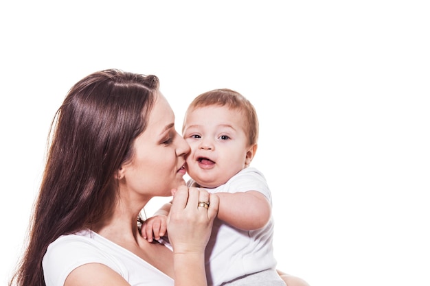 Portrait of happy mother and child embracing cheek to cheek on a white background. Mother with closed eyes holding baby's hand