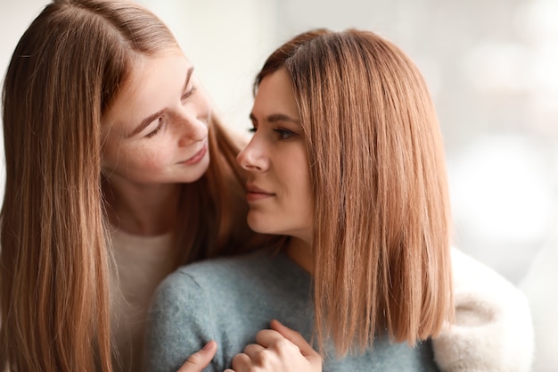 Portrait of happy mother and daughter near window