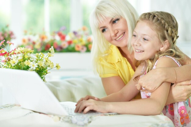 Portrait of a happy mother and daughter using laptop