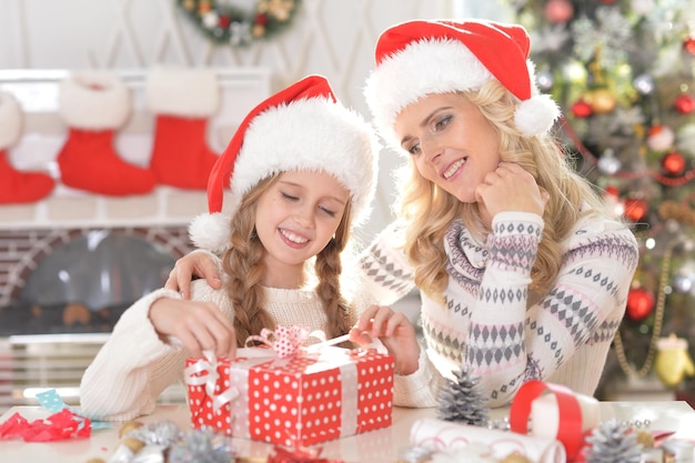 Ritratto di felice madre e figlia con regalo di natale