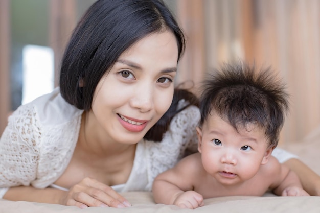 Photo portrait of a happy mother and her baby looking at you