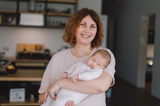 Photo portrait of happy mum holding infant child on hands