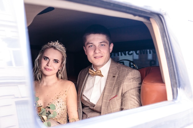 The Portrait of happy newly wed couple in car