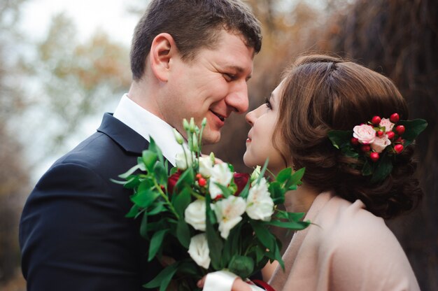 Portrait of happy newlyweds in autumn nature.
