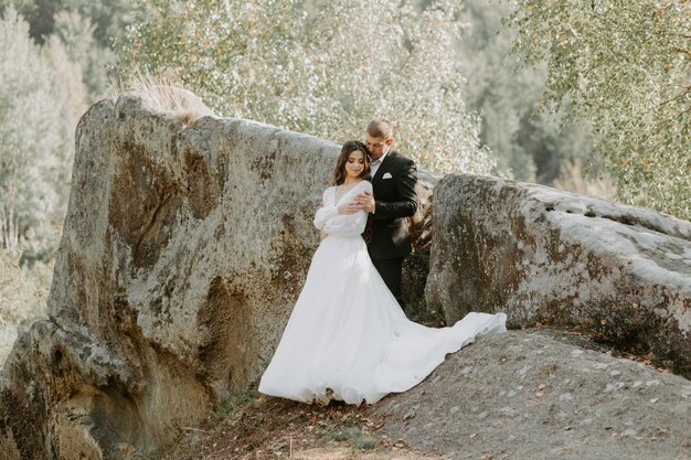 Portrait of happy newlyweds hugging, smiling and looking at each other. Concept of wedding couple