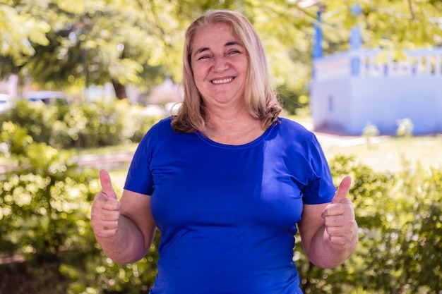 Portrait of happy older woman with thumb up