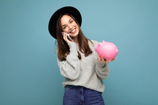 Portrait of happy positive smiling young attractive brunette woman wearing casual grey sweater and