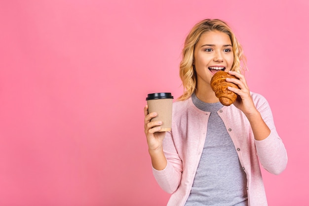 Portrait of a happy pretty teen kid girl eating croissant and drinking a coffee or a tea