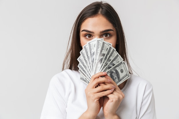 portrait of a happy pretty young woman casualy dressed isolated on white, showing money banknotes