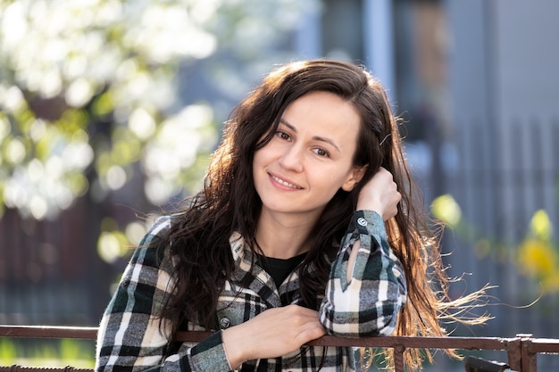 Portrait of happy pretty young woman outdoors on spring sunny day.