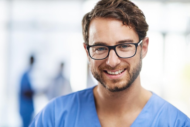 Portrait of a happy professional young doctor working as a surgeon in a hospital Confident man in the medical healthcare workspace Expert man in health smiling and ready to help or aid patients