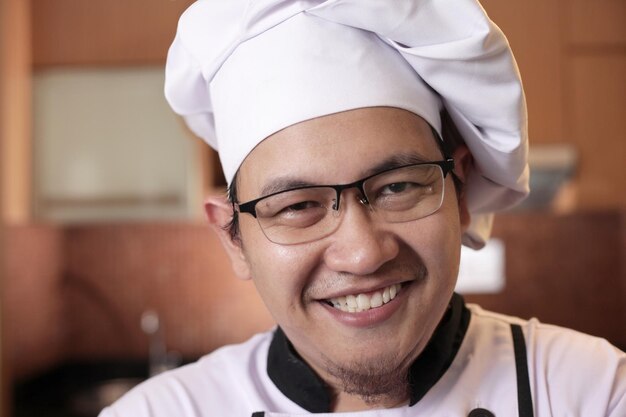 portrait of happy proud asian chef smiling at camera chef in the kitchen