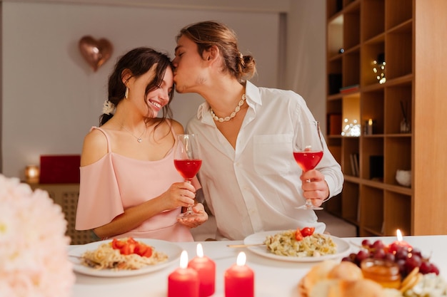 portrait of happy romantic couple drinking wine eating celebration valentines day dating love