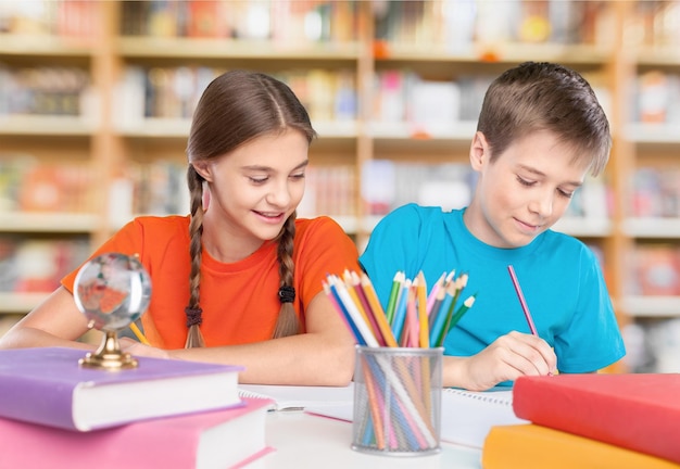 Portrait of happy school children drawing with crayons