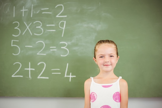 Portrait of happy schoolgirl smiling in classroom