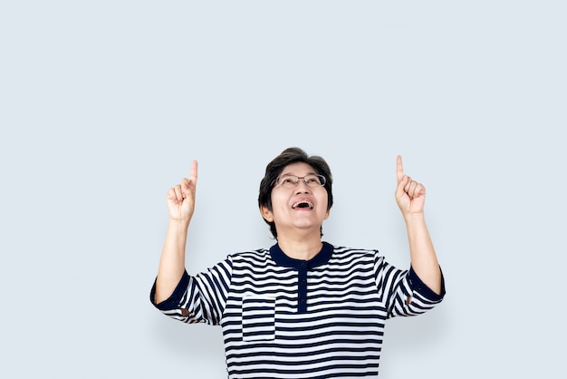 Portrait of happy senior asian woman gesture or pointing hand and finger up