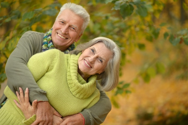 Portrait of a happy senior couple in autumn park