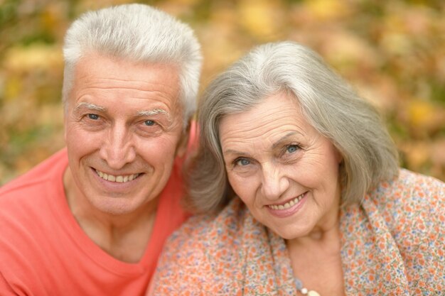 Portrait of a happy senior couple in autumn park