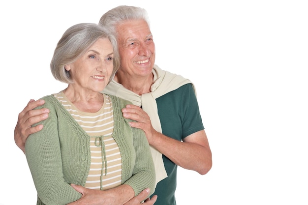 Portrait of happy senior couple embracing on white background