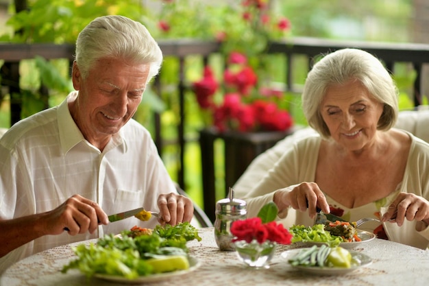 Foto ritratto delle coppie senior felici che mangiano cena