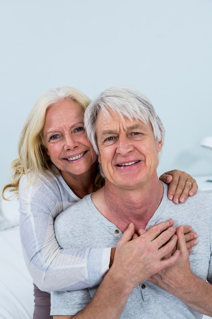 Portrait of happy senior couple hugging at home