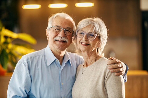 カメラに抱きしめて微笑む幸せな高齢夫婦の肖像画