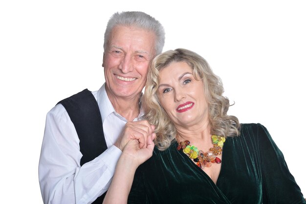 Portrait of happy senior couple hugging on white background