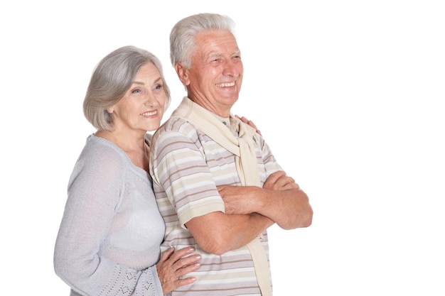 Portrait of happy senior couple hugging on white background