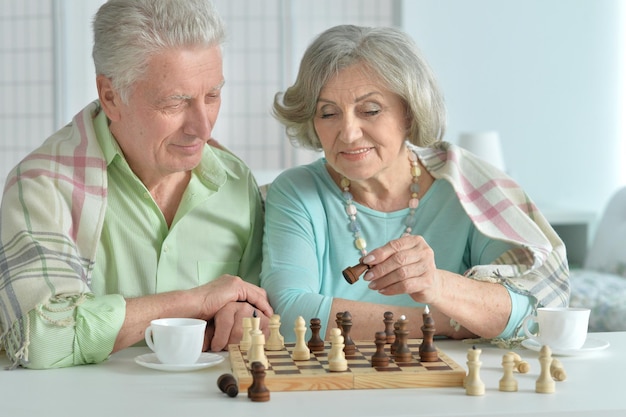 Portrait of a happy senior couple playing chess