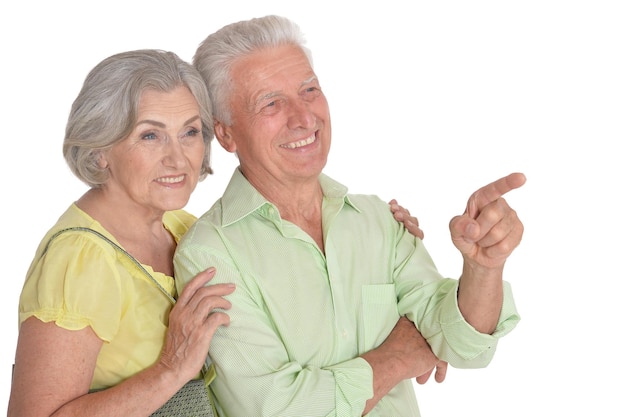 Portrait of a happy senior couple pointing to the right