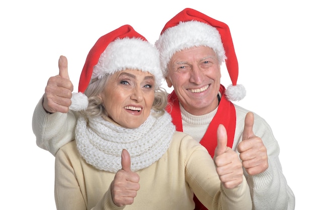 Portrait of happy senior couple in Santa hats isolated on white background