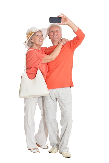 Portrait of happy senior couple taking selfie photo at white background