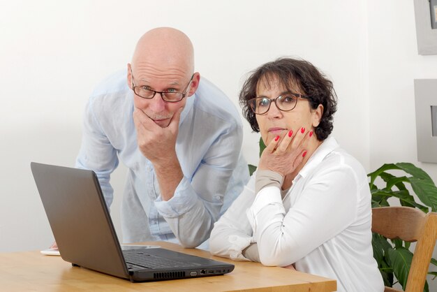 Portrait of a happy senior couple using laptop